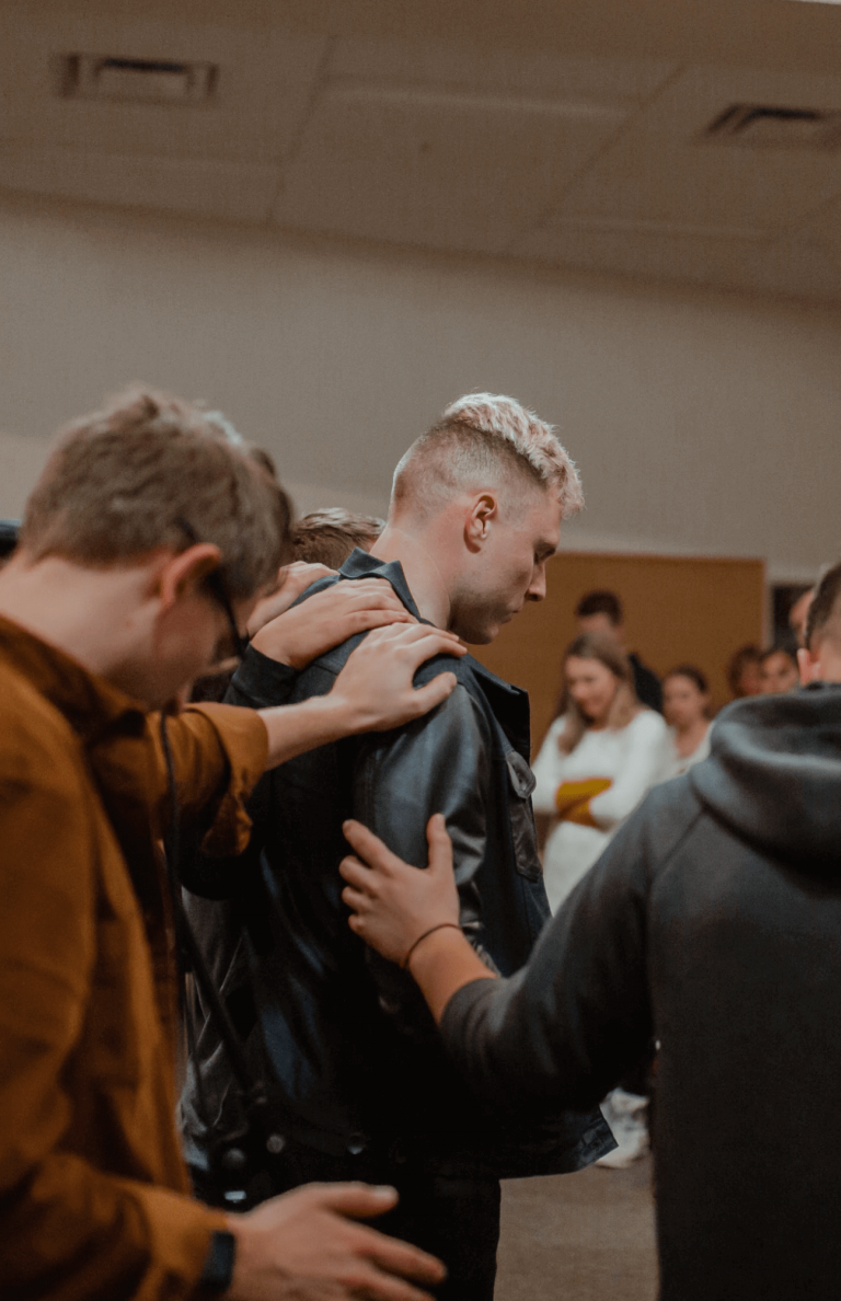 Group praying over their friend at church
