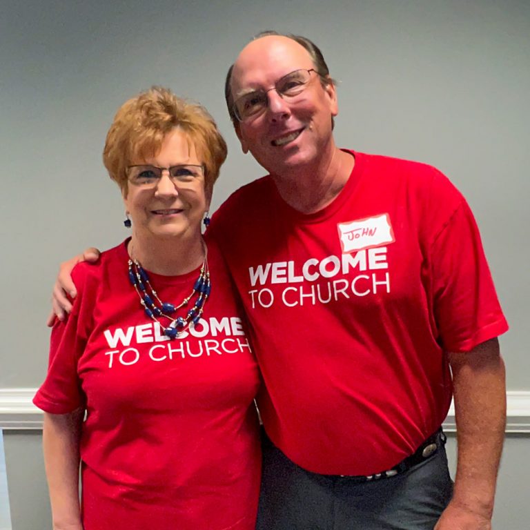 couple who serves as greeters pose for photo